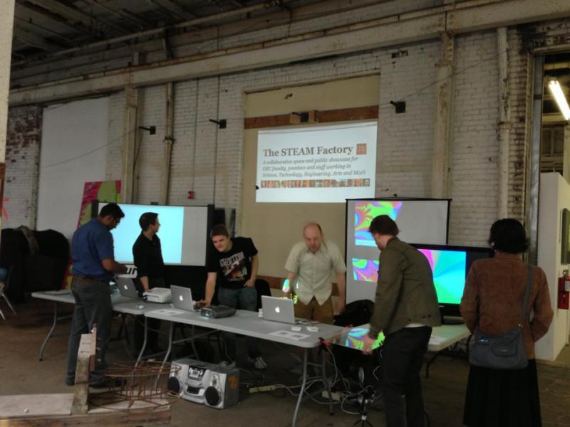 STEAM Factory members setting up for the first ever 400 W. Rich Farmer's Market, where GesturDB was test out. STEAM Factory members at table setting up for event.