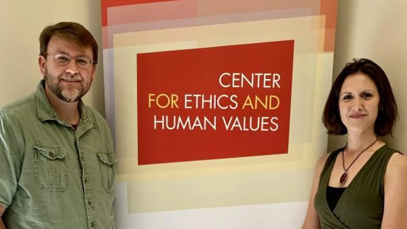 Piers Turner, Director, and Kate McFarland, Associate Director, standing next to the Center for Ethics and Human Values logo