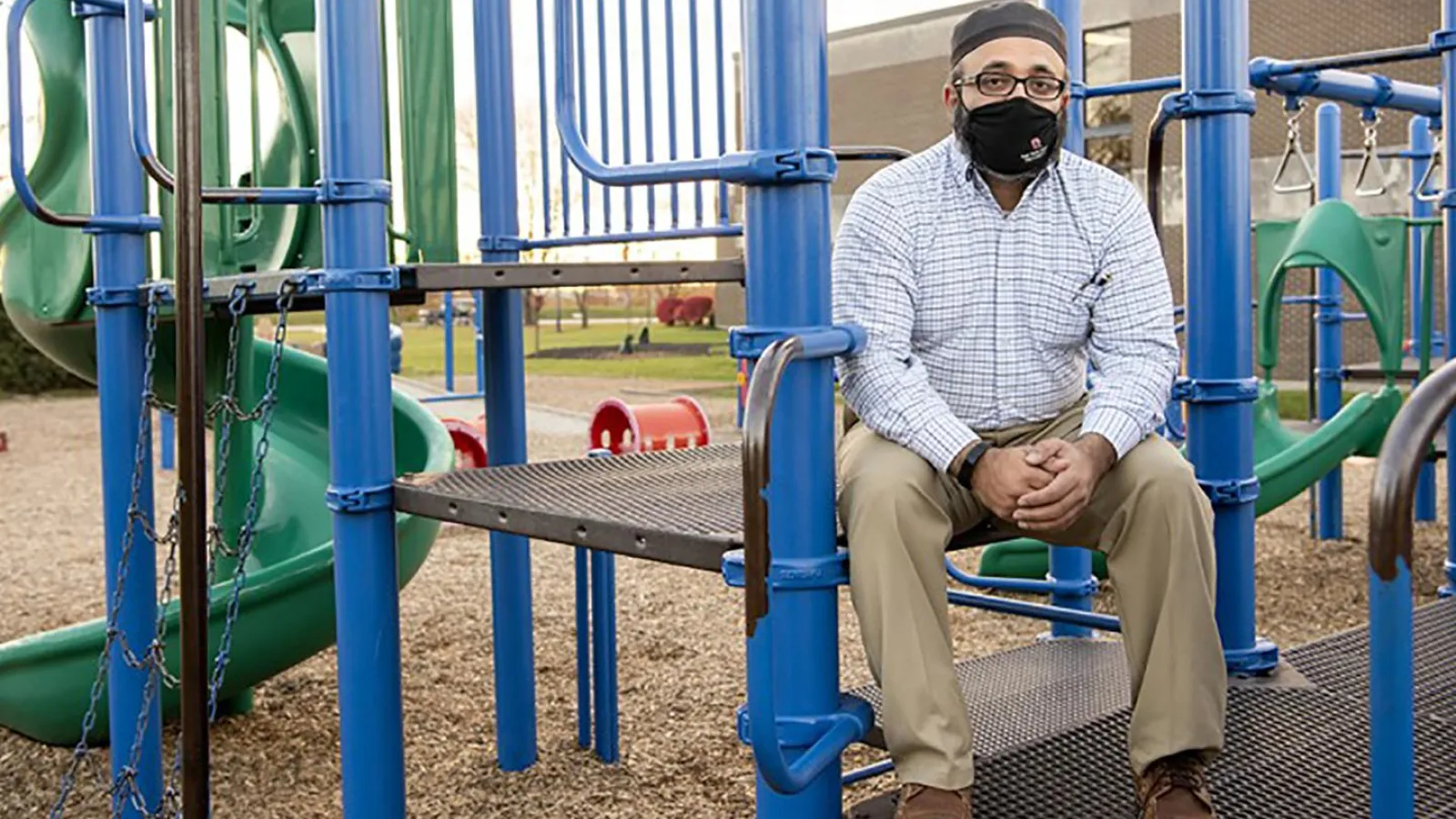 Ayaz Hyder sitting at a playground