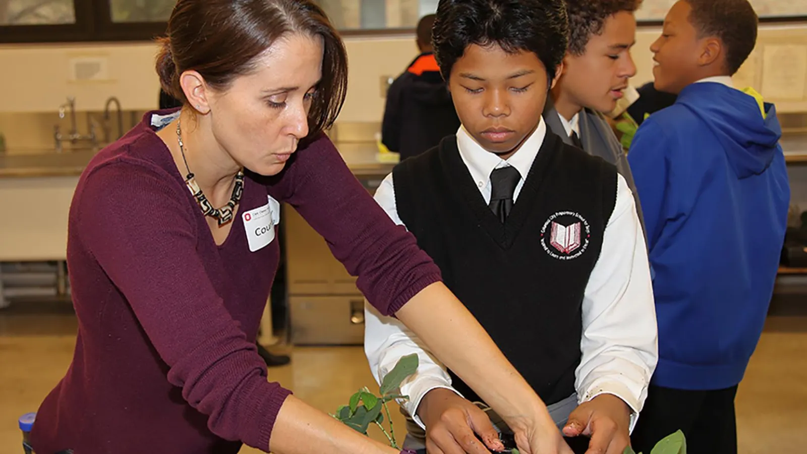 Courtney Price helping a young student with plant samples