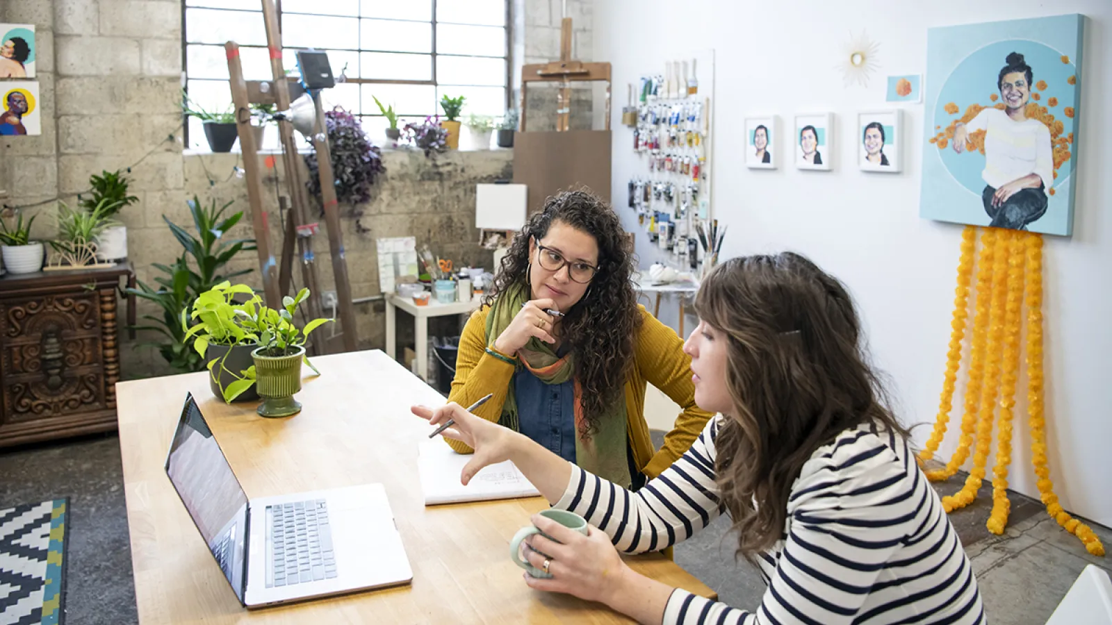 Mary Rodriguez focusing on a women who is gesturing towards her laptop screen