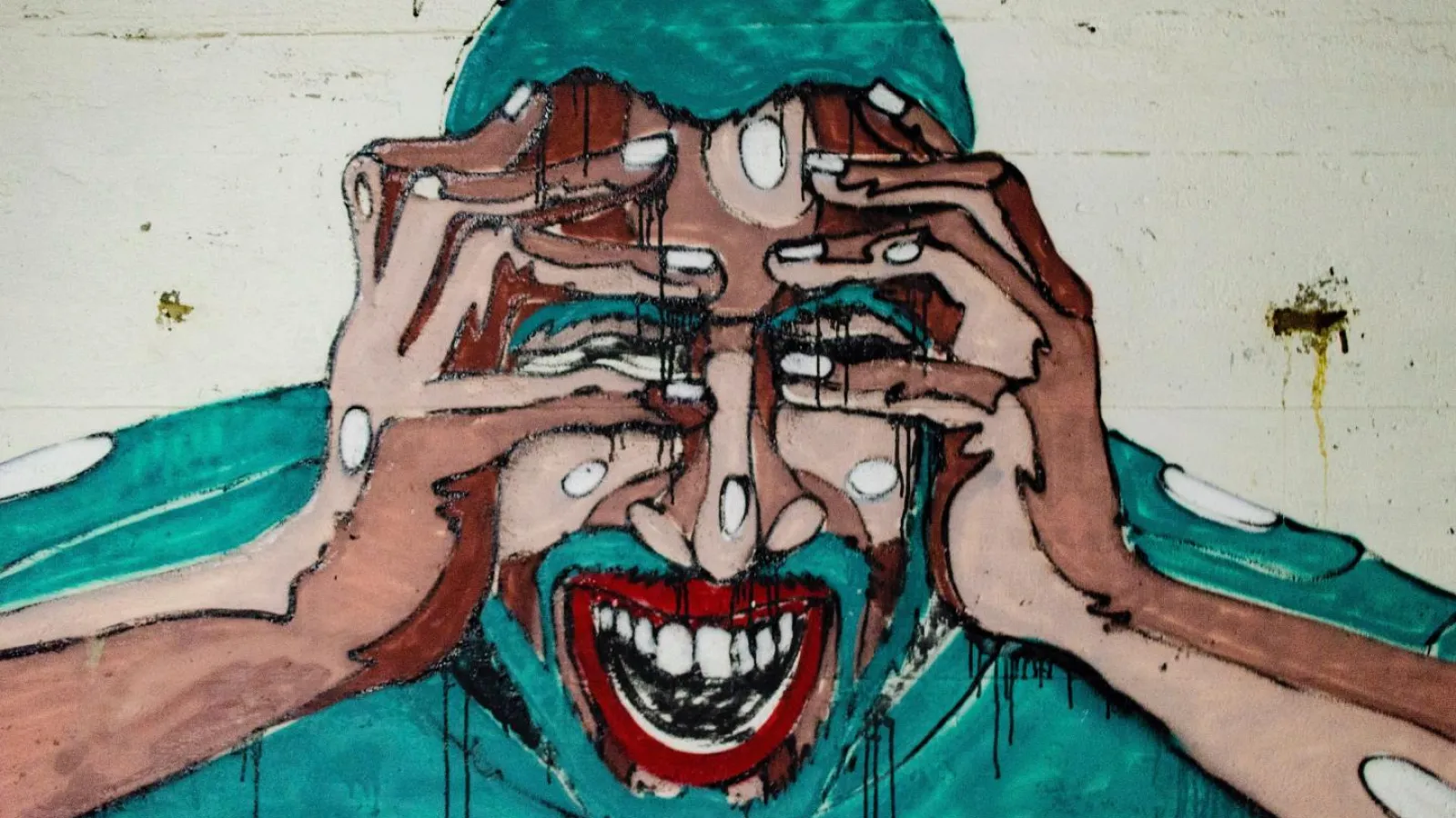 Mural on a wall of a man showing extreme signs of stress