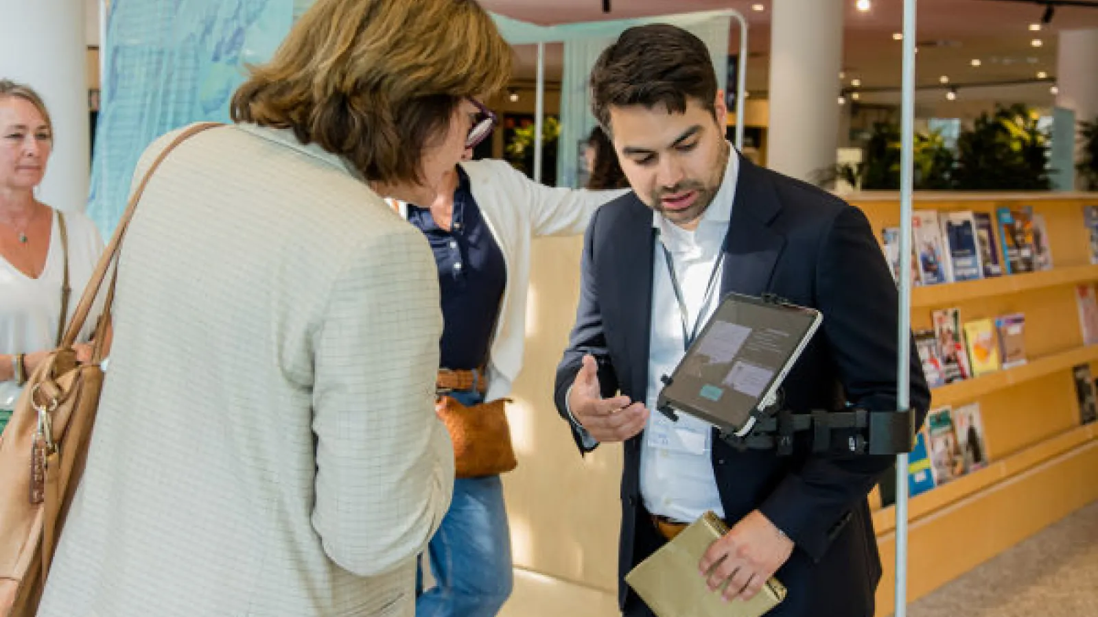 Man explains as woman engages in interactive screen