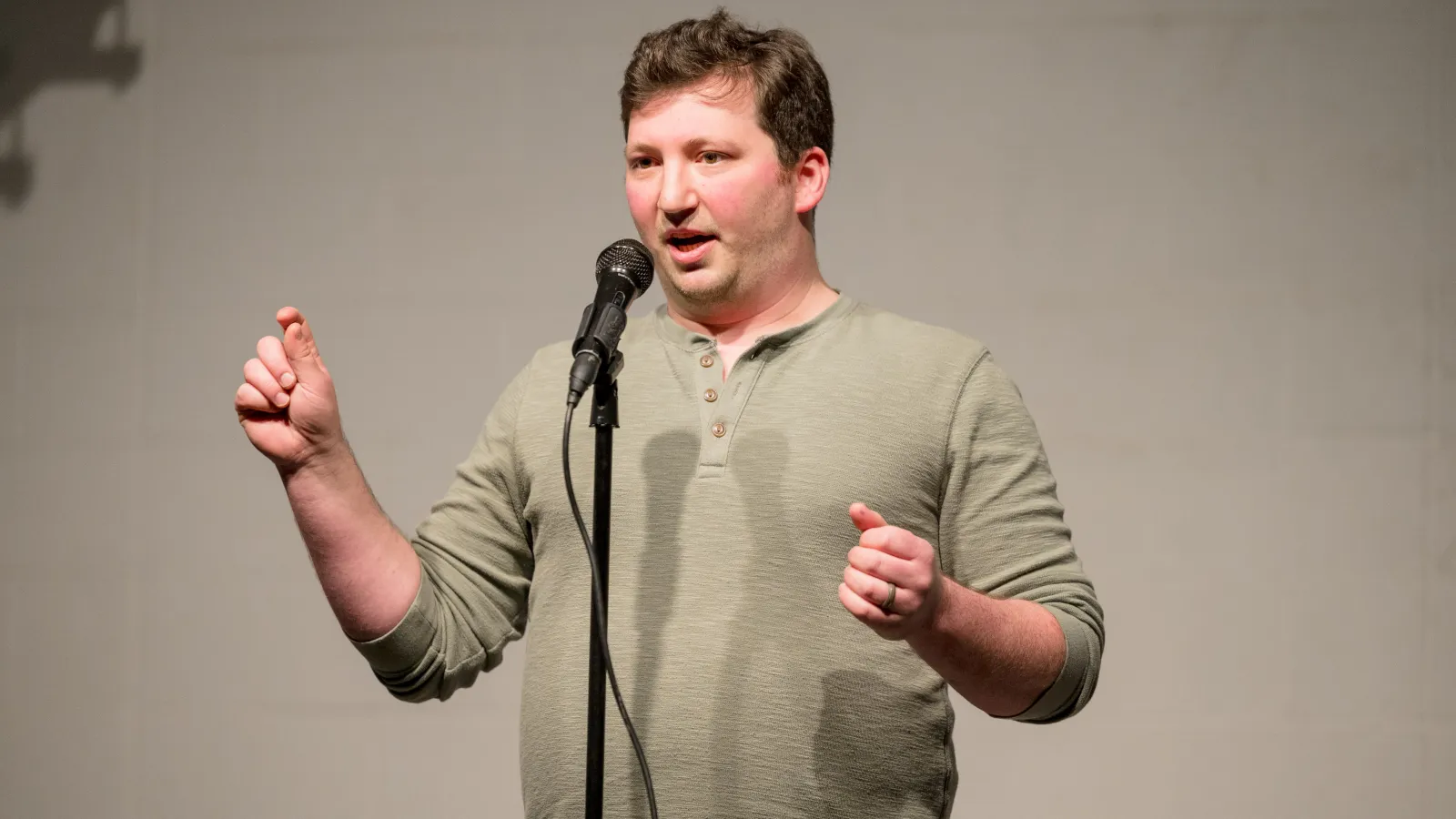 A man standing behind a microphone speaking
