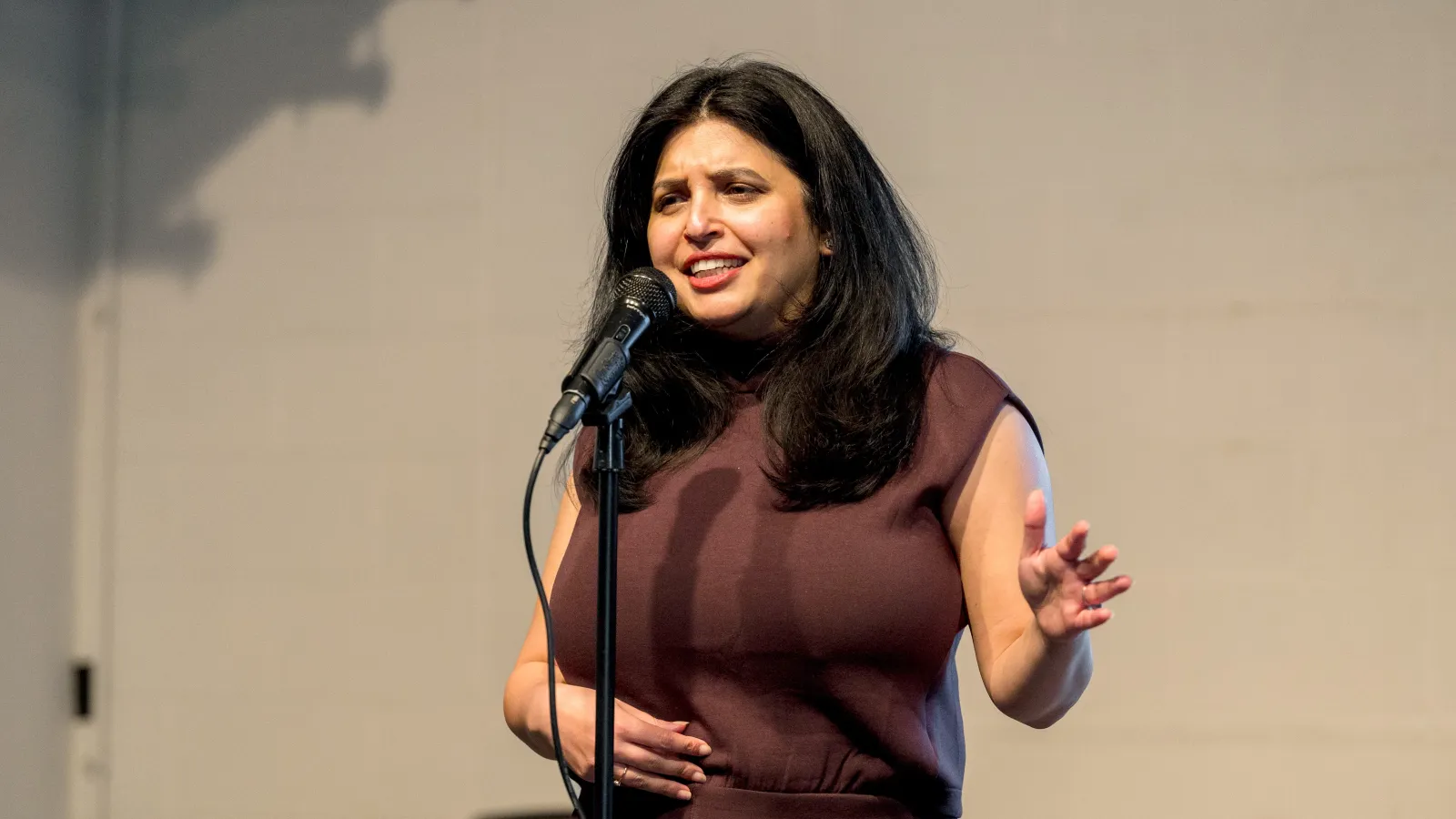 A woman standing behind a microphone speaking