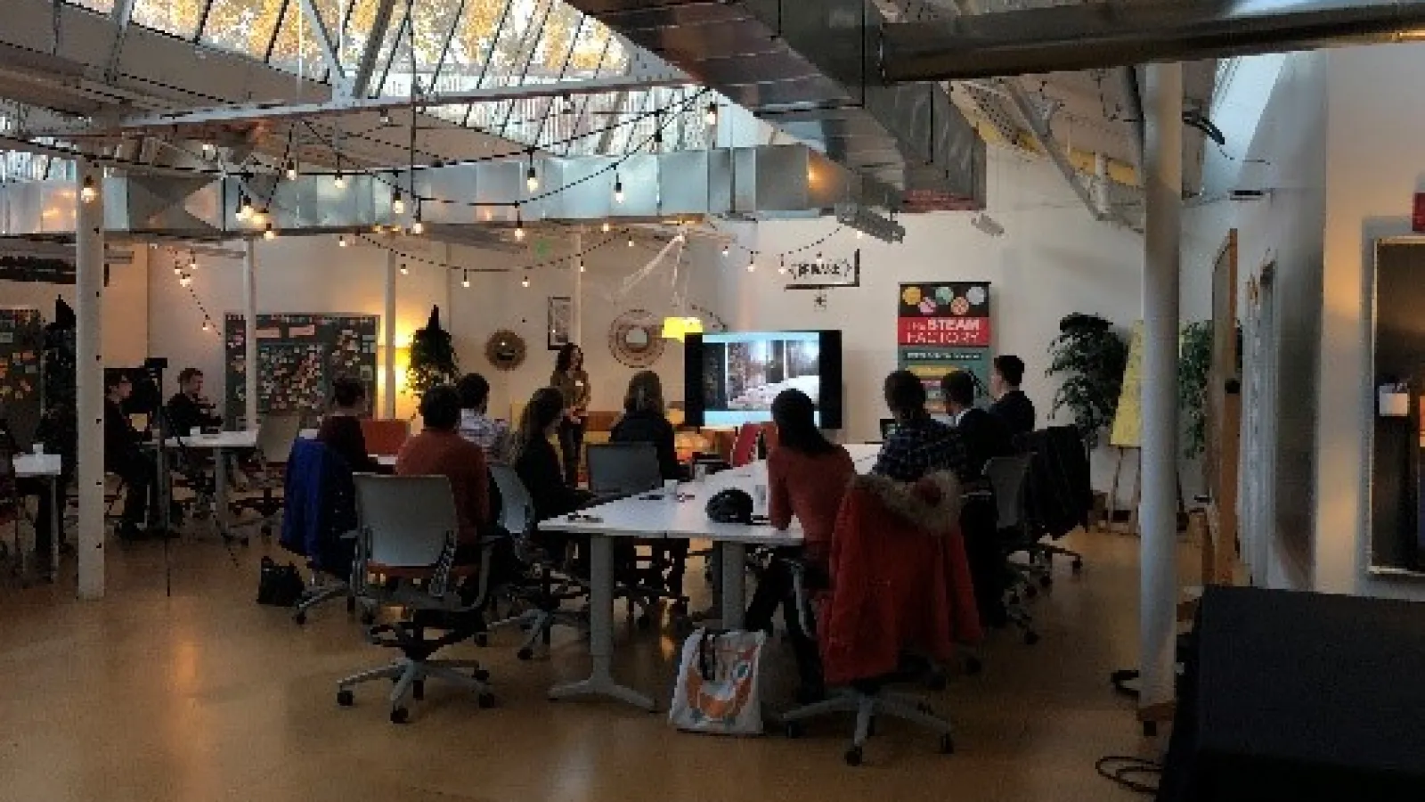 STEAM Members sitting at a table watching a presentation