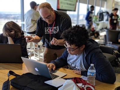 Student looking down at his laptop as an advisor is helping him