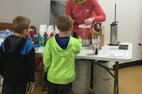 Presenter and children experiment with liquid nitrogen