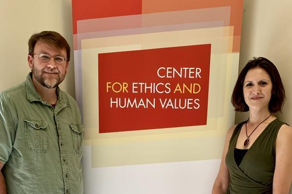 Piers Turner, Director, and Kate McFarland, Associate Director, standing next to the Center for Ethics and Human Values logo