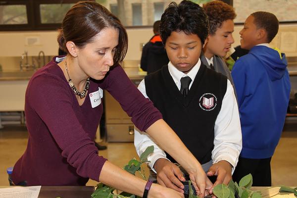 Courtney Price helping a young student with plant samples