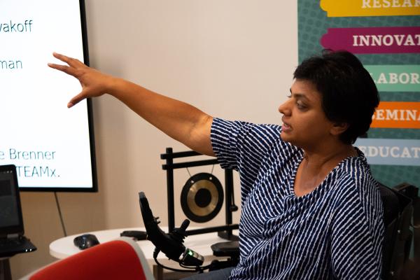 STEAM Member Sathya Gopalakrishnan pointing towards a presentation