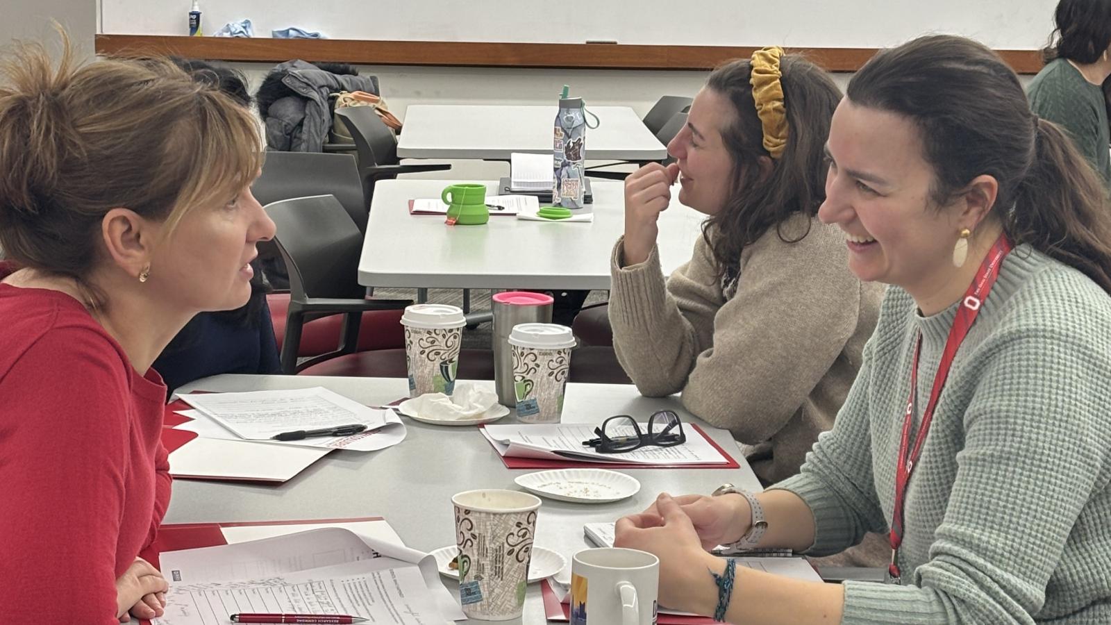 Two women sitting across from each other at a table talking