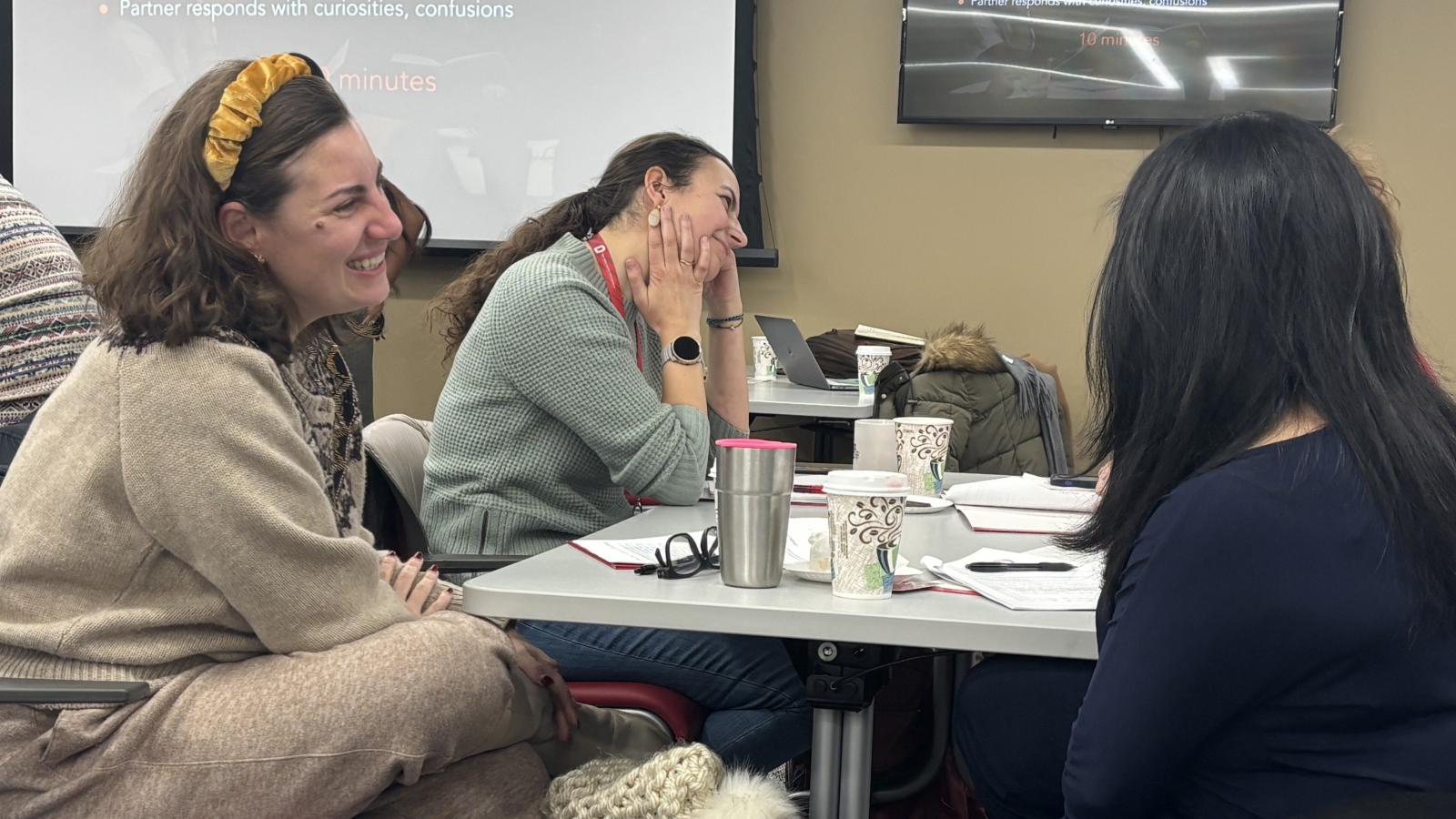 Three women at a table engaged in conversation