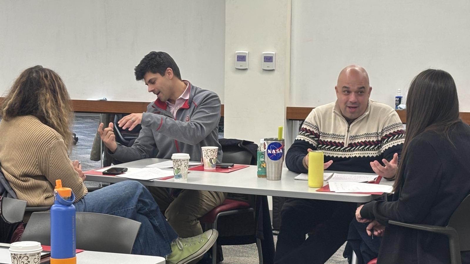 Four people at a table talking