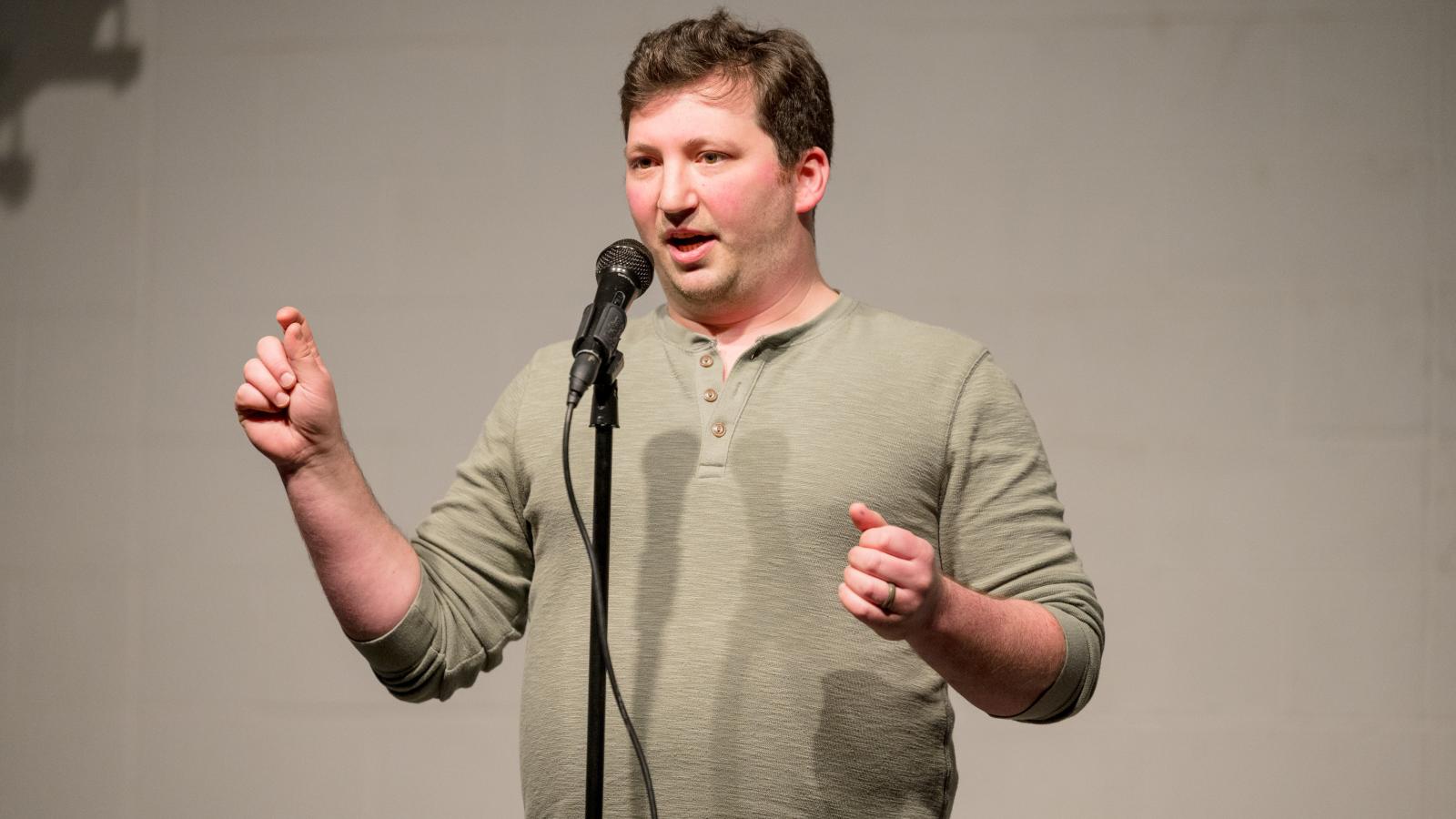 A man standing behind a microphone speaking