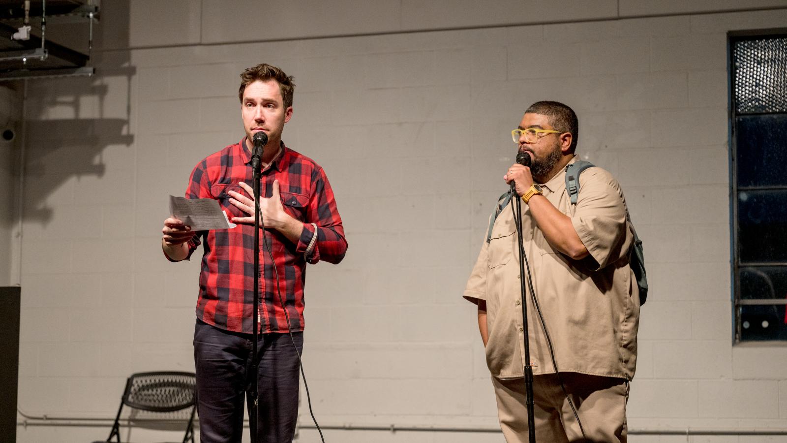 Two men standing on stage with mircrophones